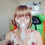 blonde white lady with a nebulizer breathing mask/tube