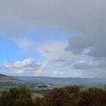 a rainbow in a blue sky with clouds