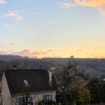 a sky and misty hills behind some houses