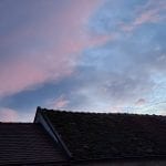 colorful sunrise clouds above roofs