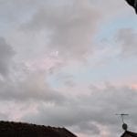 light blue sky with grey and pink clouds