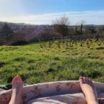 feet on a picnic blanket overlooking vineyards