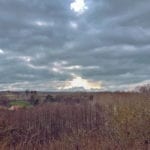 a cloudy sky above a not-yet-spring-looking landscape