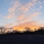 sunrise with pink clouds over rooftop