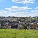 a French village in a valley under a blue sky