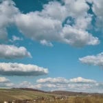 fluffy clouds in a blue sky over French countryside