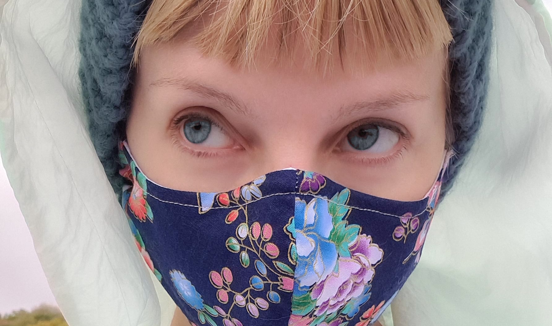 blonde white lady wearing a floral face mask