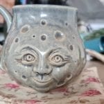 a tea mug with a moon face
