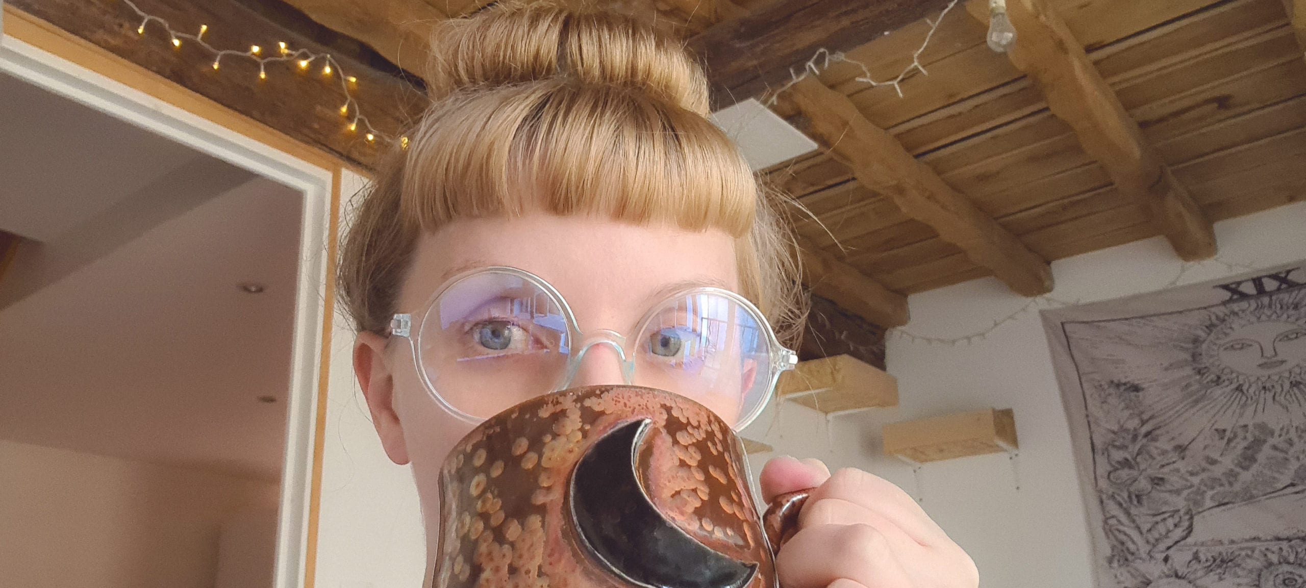 blonde white lady with short bangs (fringe) drinking out of a large mug