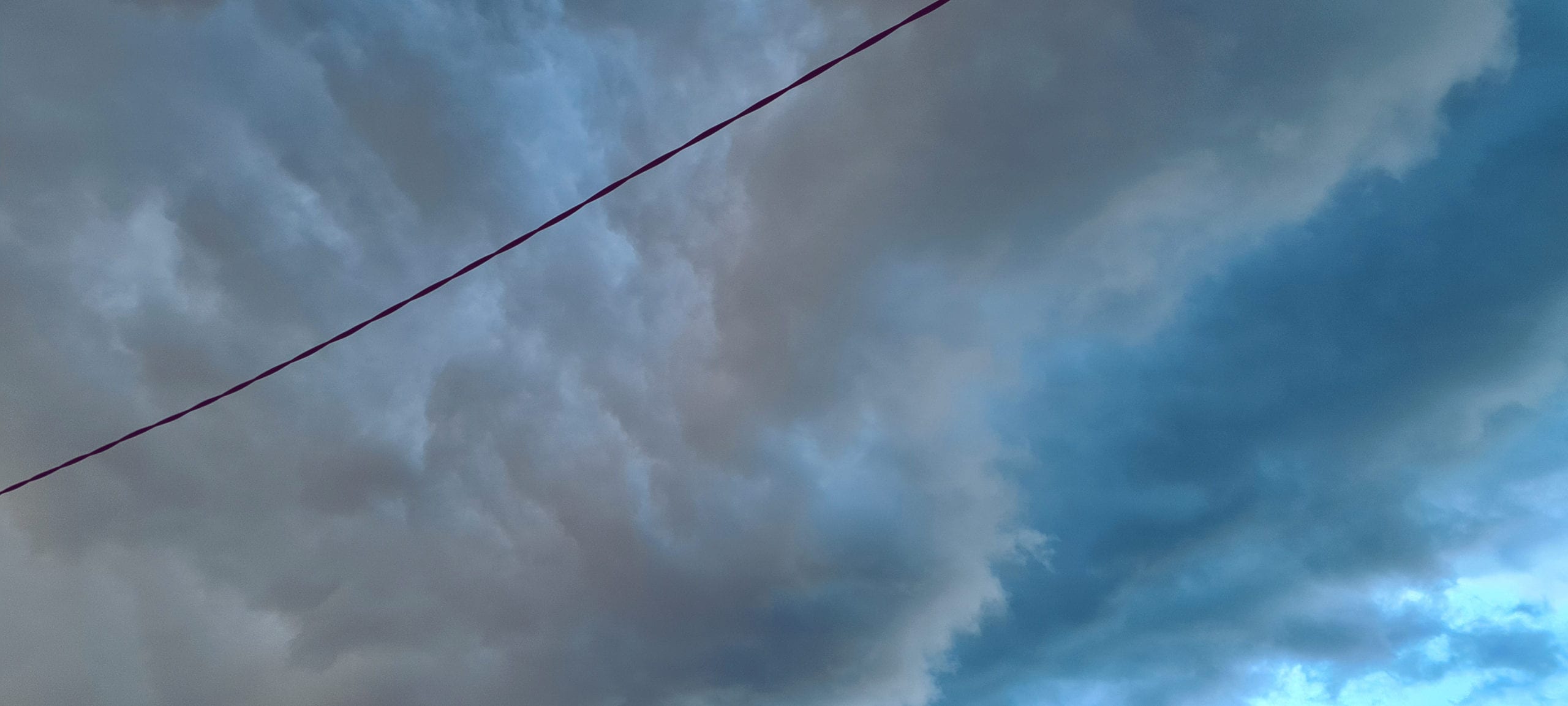 a cloudy sky with both blue sky and rain clouds