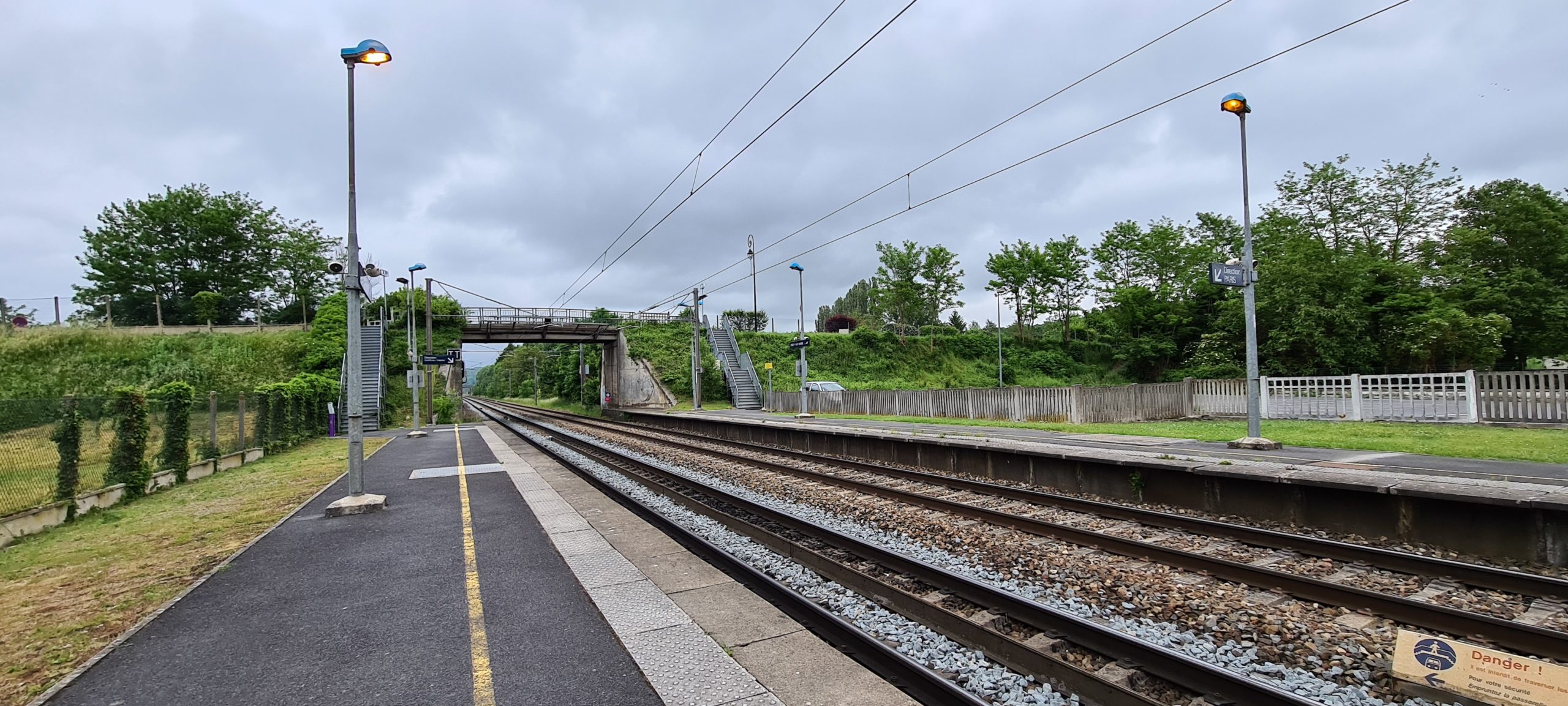 train tracks going under a small road bridge