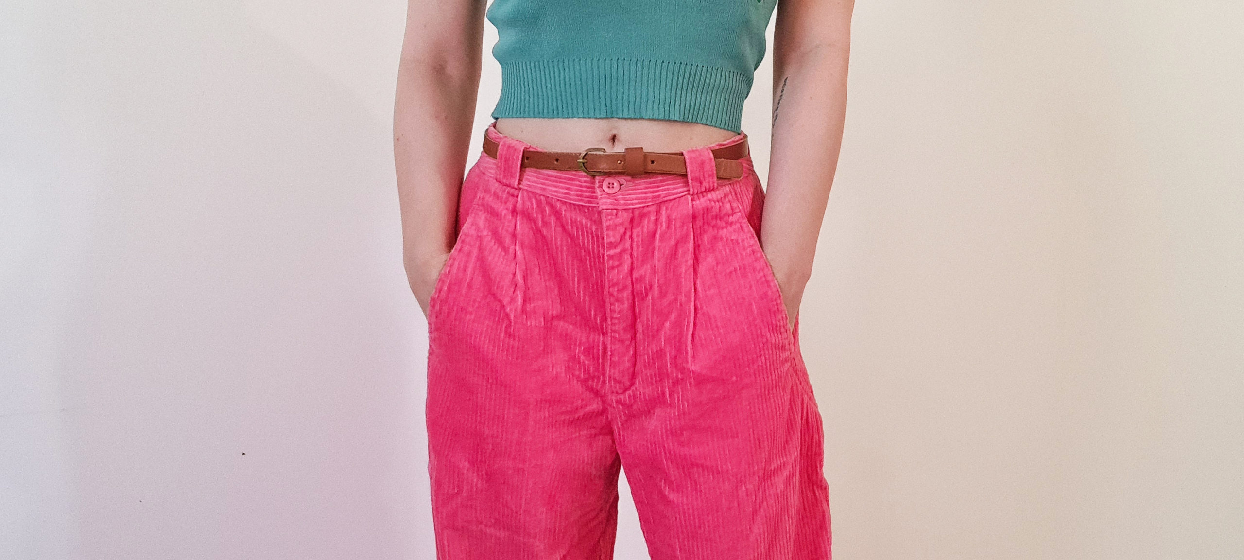 hot pink corduroy trousers being worn with a brown leather belt