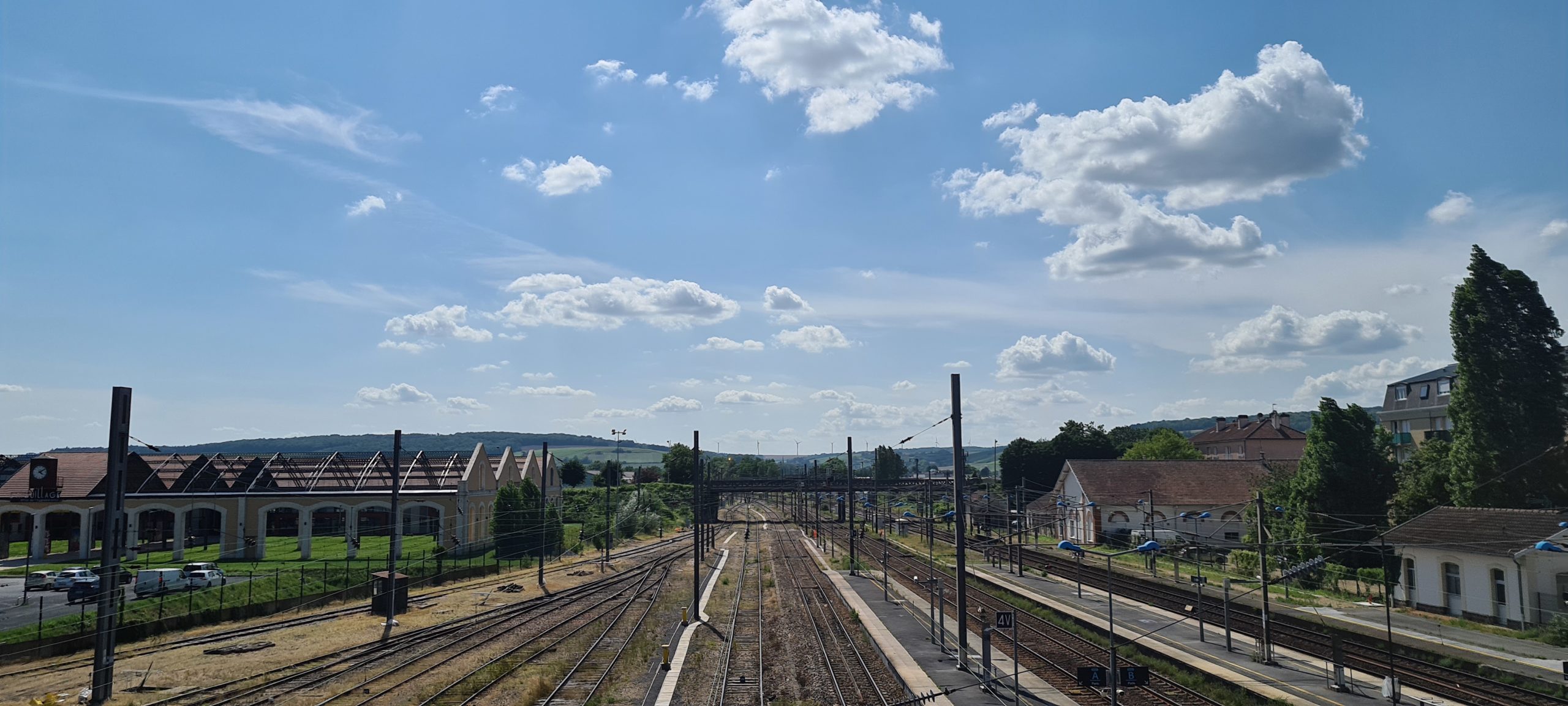 blue sky with white clouds over train tracks