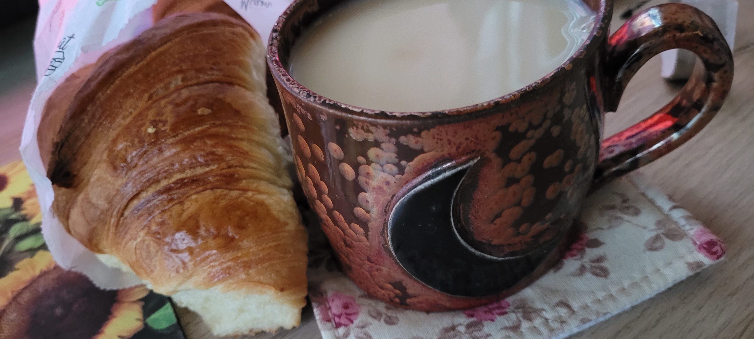 a croissant and large mug of milk tea