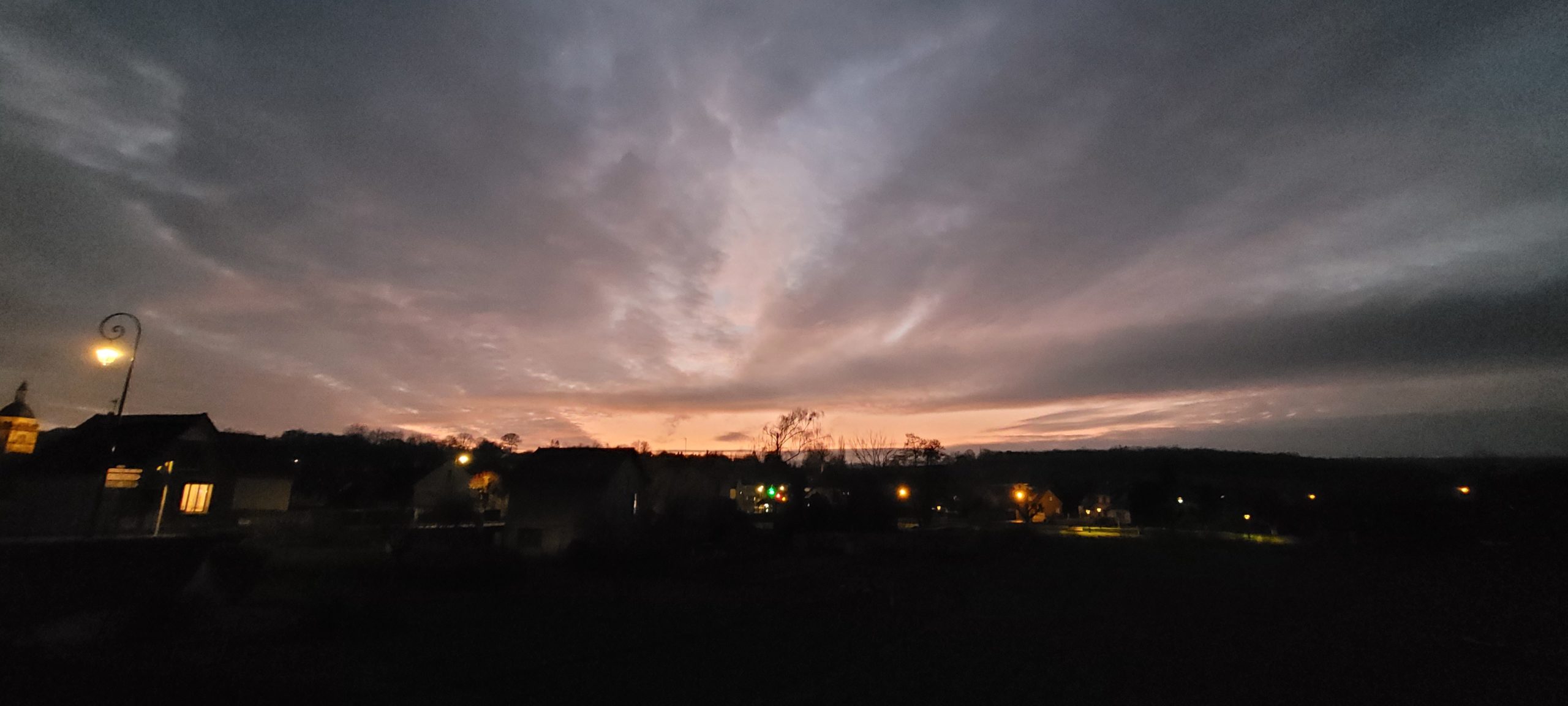 end of a peach colored sunset with clouds