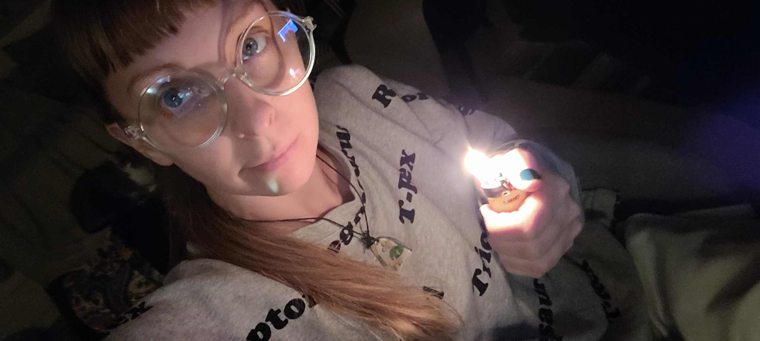 a white woman holding a lighter in the dark