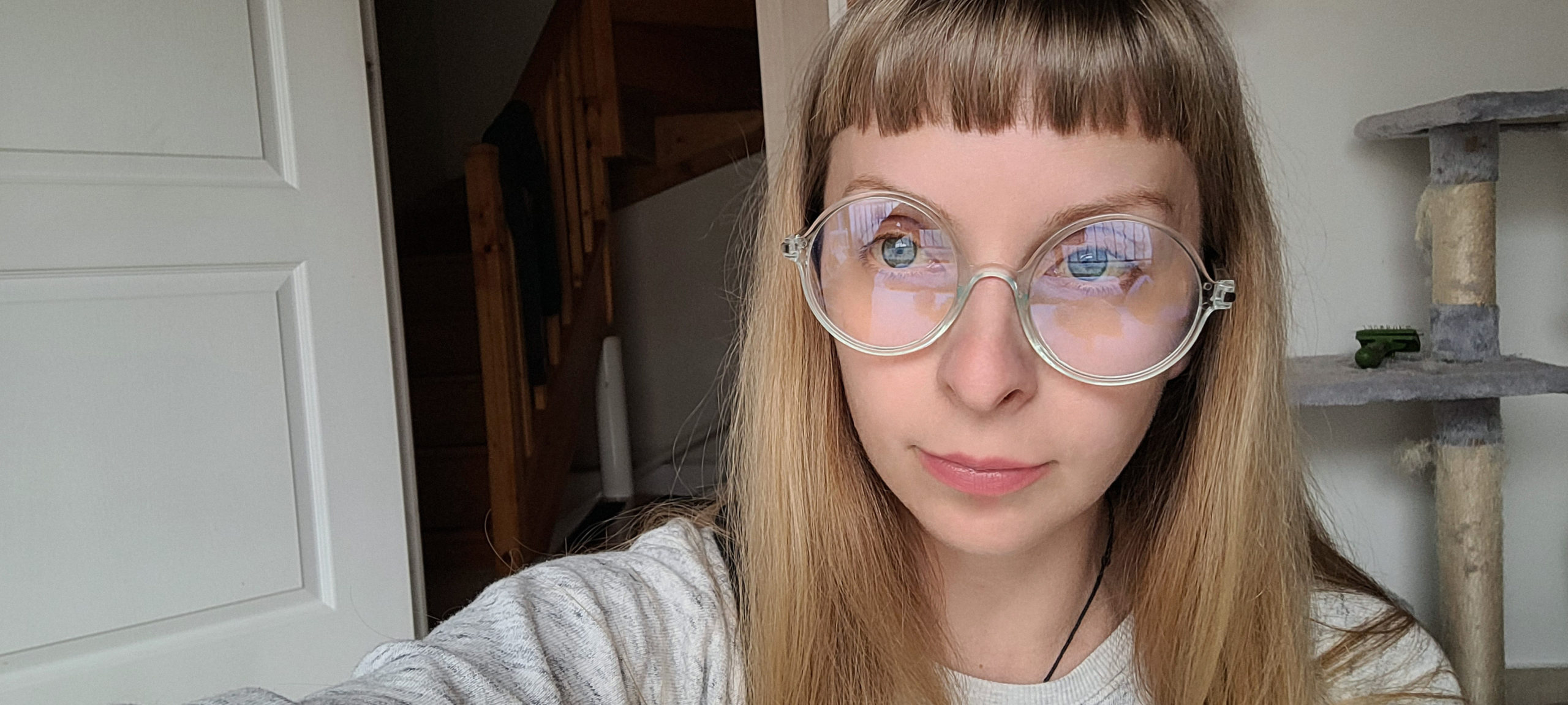 selfie of blonde woman in round clear glasses