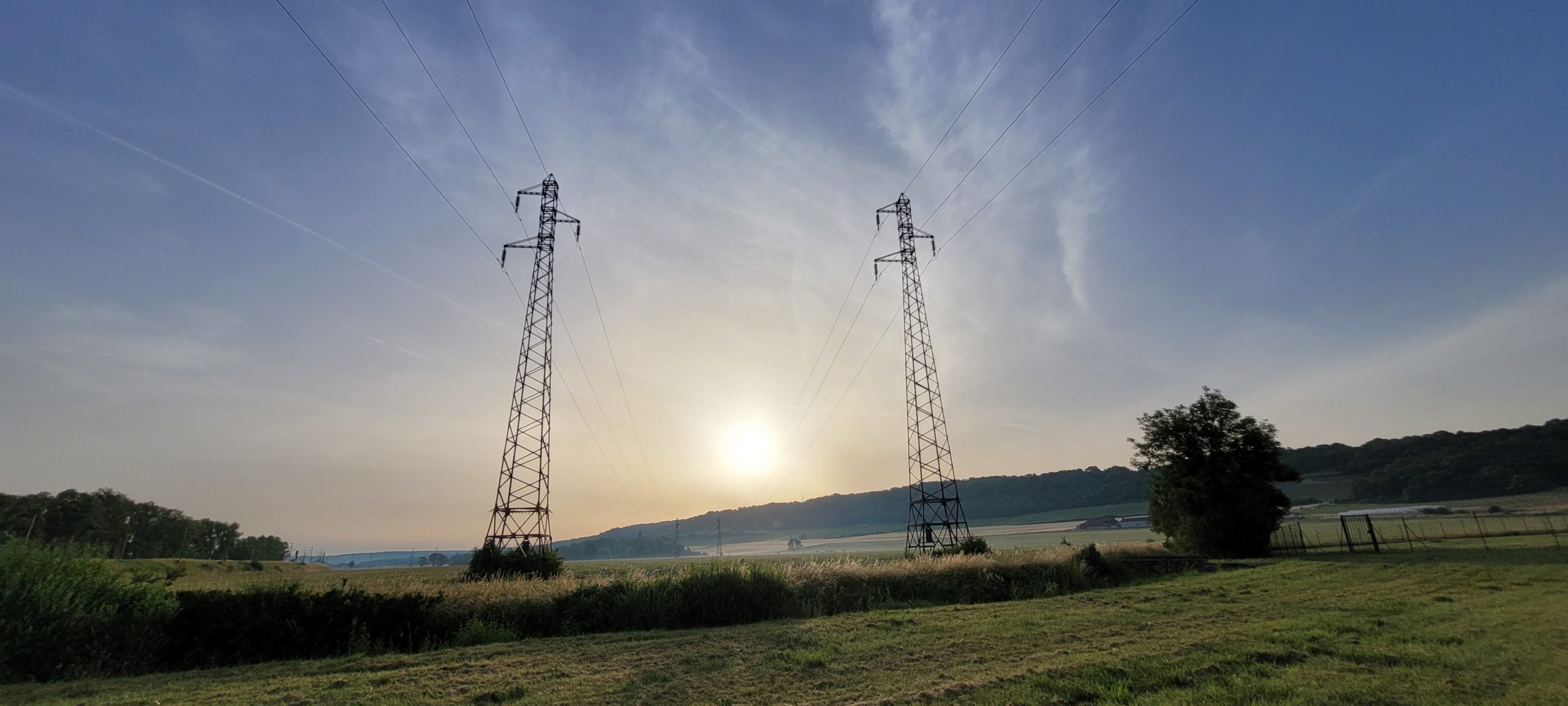 power line metal towers in front of a sunrise