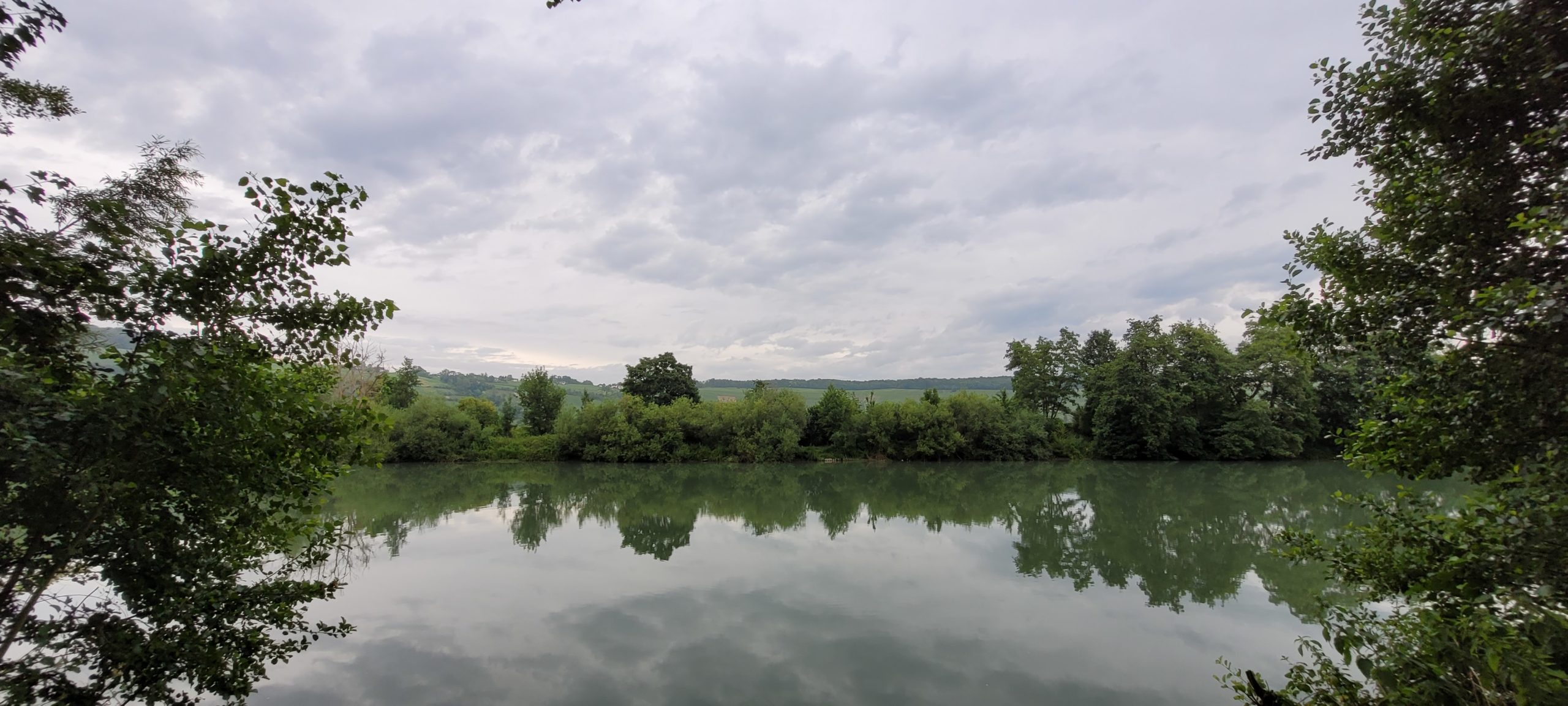 cloudy sky over a river lined with trees