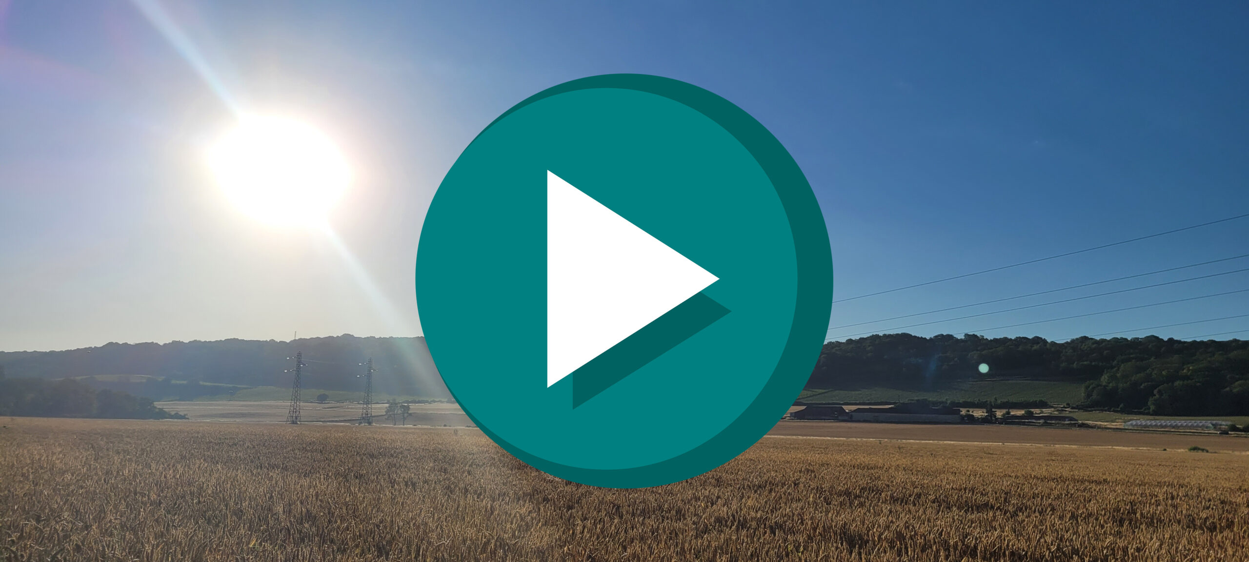 sunrise over fields with a play button on top