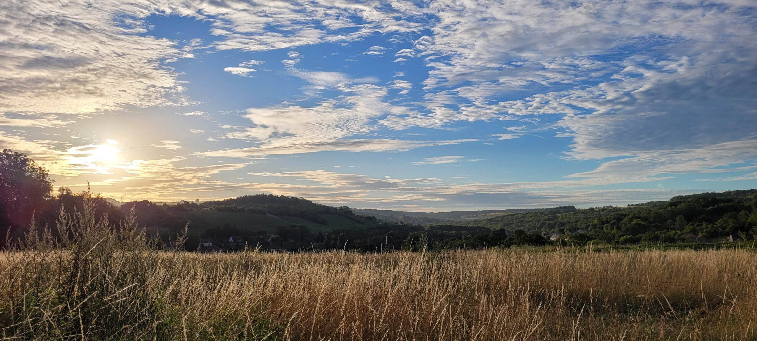 sunrise over french countryside, white thin clouds in a blue sky