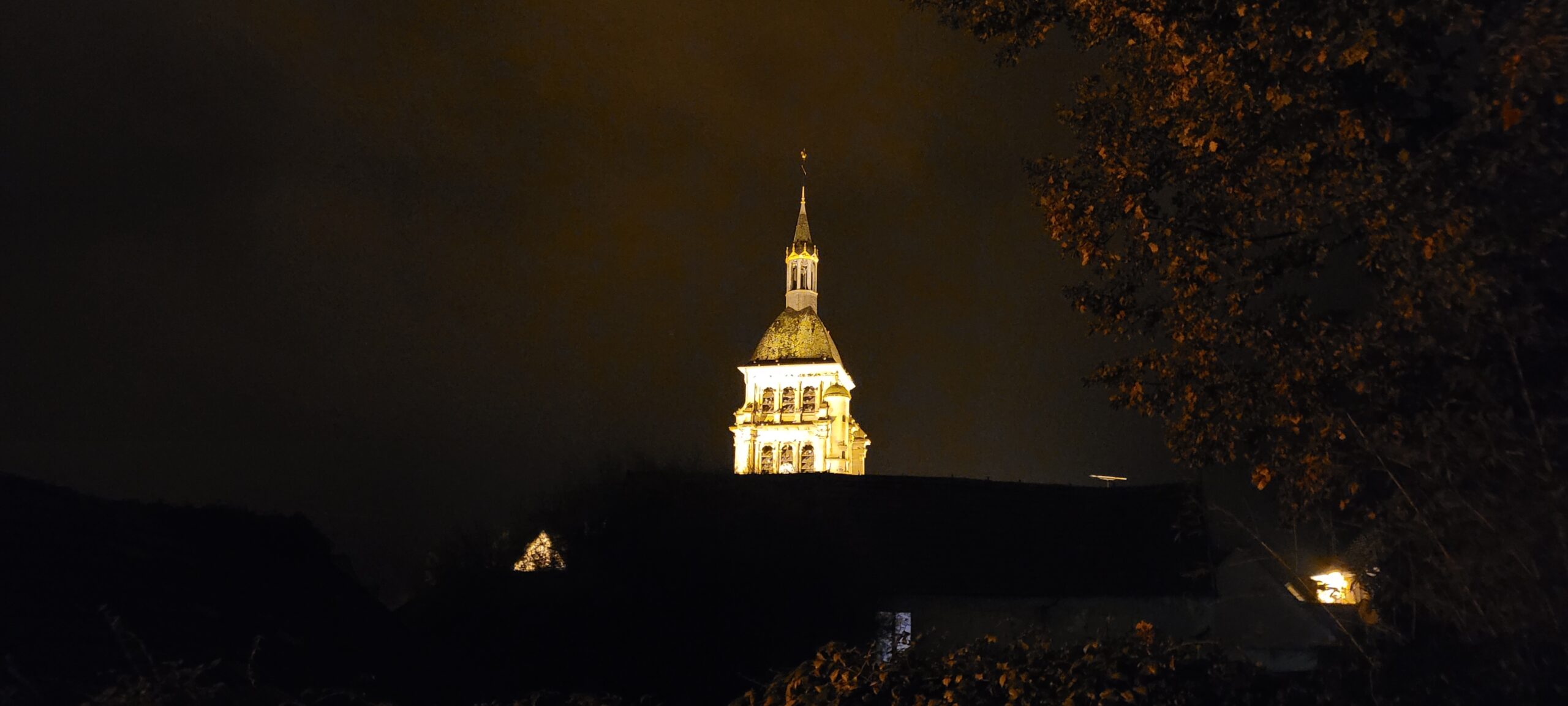 the top of a church lit up at night