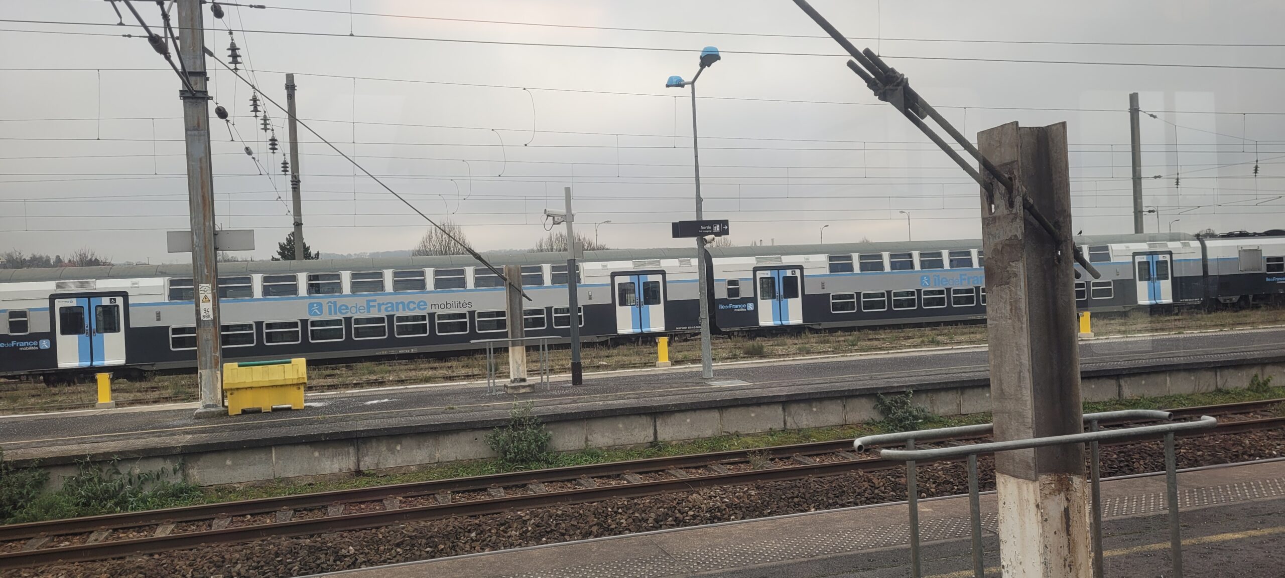 a train parked at a train platform on a cloudy day