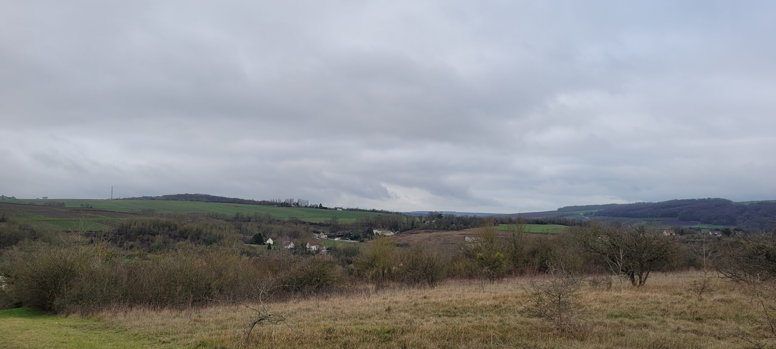 a grey cloudy sky over french countryside