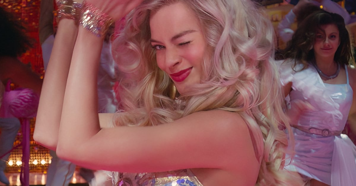 screenshot of Margot Robbie from the Barbie movie, she is winking and clapping while dancing